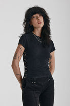 Acid wash black baby t-shirt with short sleeves and silver O-ring hardware, worn by model