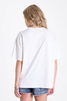 White oversized t-shirt with skeleton jester graphic print, worn by model