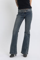 Vintage wash low rise flare jeans with eyelet and horsebit clasp belt, worn by model