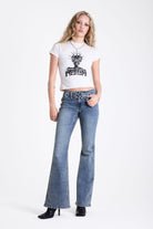 Vintage wash low rise flare jeans with oversized eyelet buckle belt, worn by mdoel