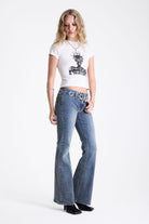 Vintage wash low rise flare jeans with oversized eyelet buckle belt, worn by mdoel