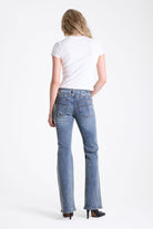 Vintage wash low rise flare jeans with oversized eyelet buckle belt, worn by mdoel