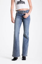 Vintage wash low rise flare jeans with oversized eyelet buckle belt, worn by mdoel
