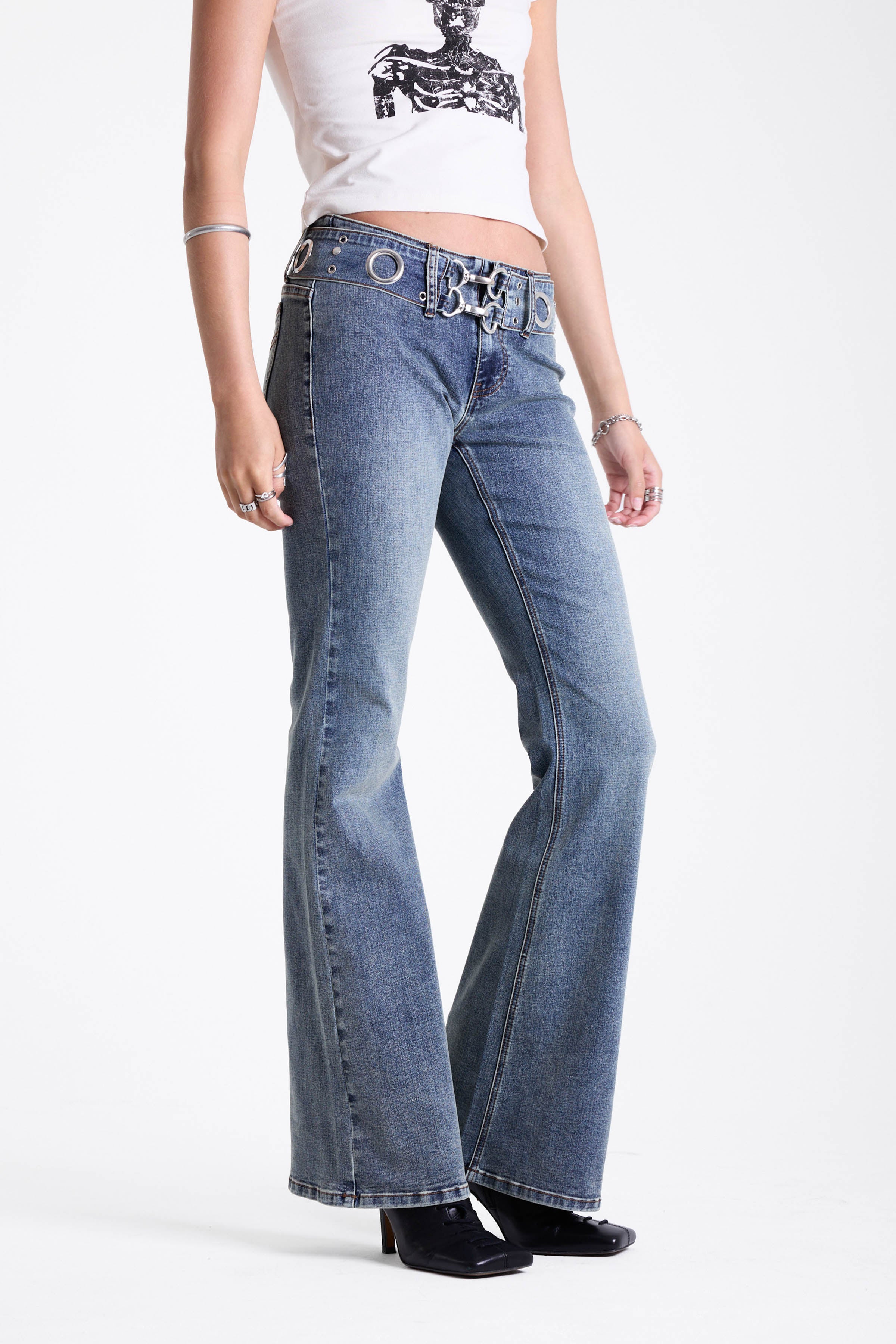 Vintage wash low rise flare jeans with oversized eyelet buckle belt, worn by mdoel