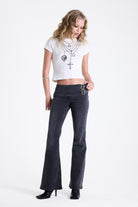 Washed black flare bootcut jeans with double buckle belt detail, worn by model