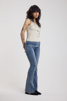 Blue flare bootcut jeans with double buckle belt detail, worn by model