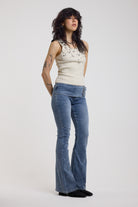 Blue flare bootcut jeans with double buckle belt detail, worn by model