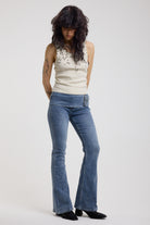 Blue flare bootcut jeans with double buckle belt detail, worn by model