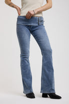 Blue flare bootcut jeans with double buckle belt detail, worn by model