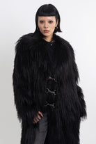 Longline black shaggy faux fur coat with silver horsebit clasps and shawl collar, worn by model