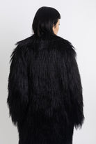 Longline black shaggy faux fur coat with silver horsebit clasps and shawl collar, worn by model