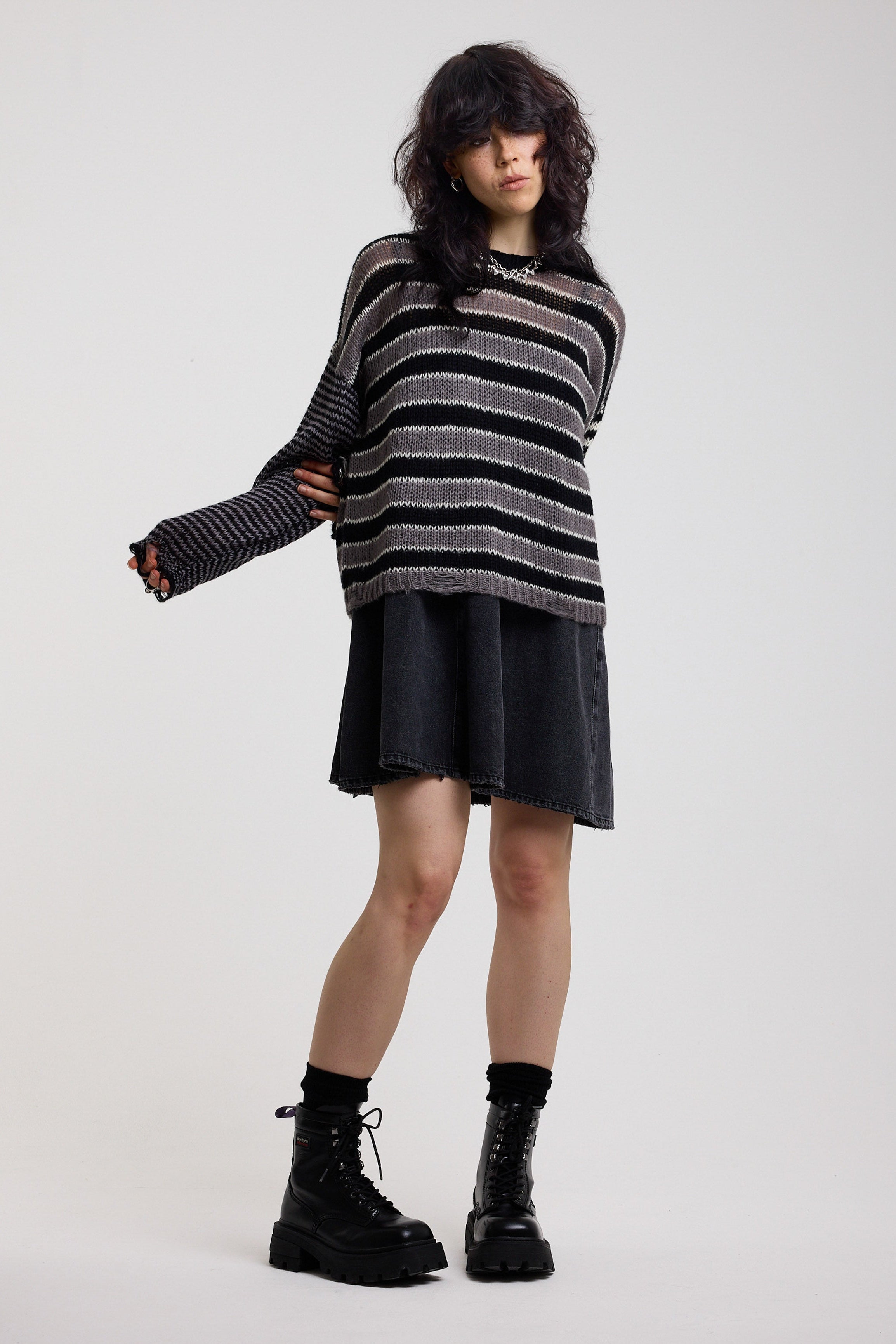 Black and white stripe oversized knit jumper with grunge distressed details, worn by model