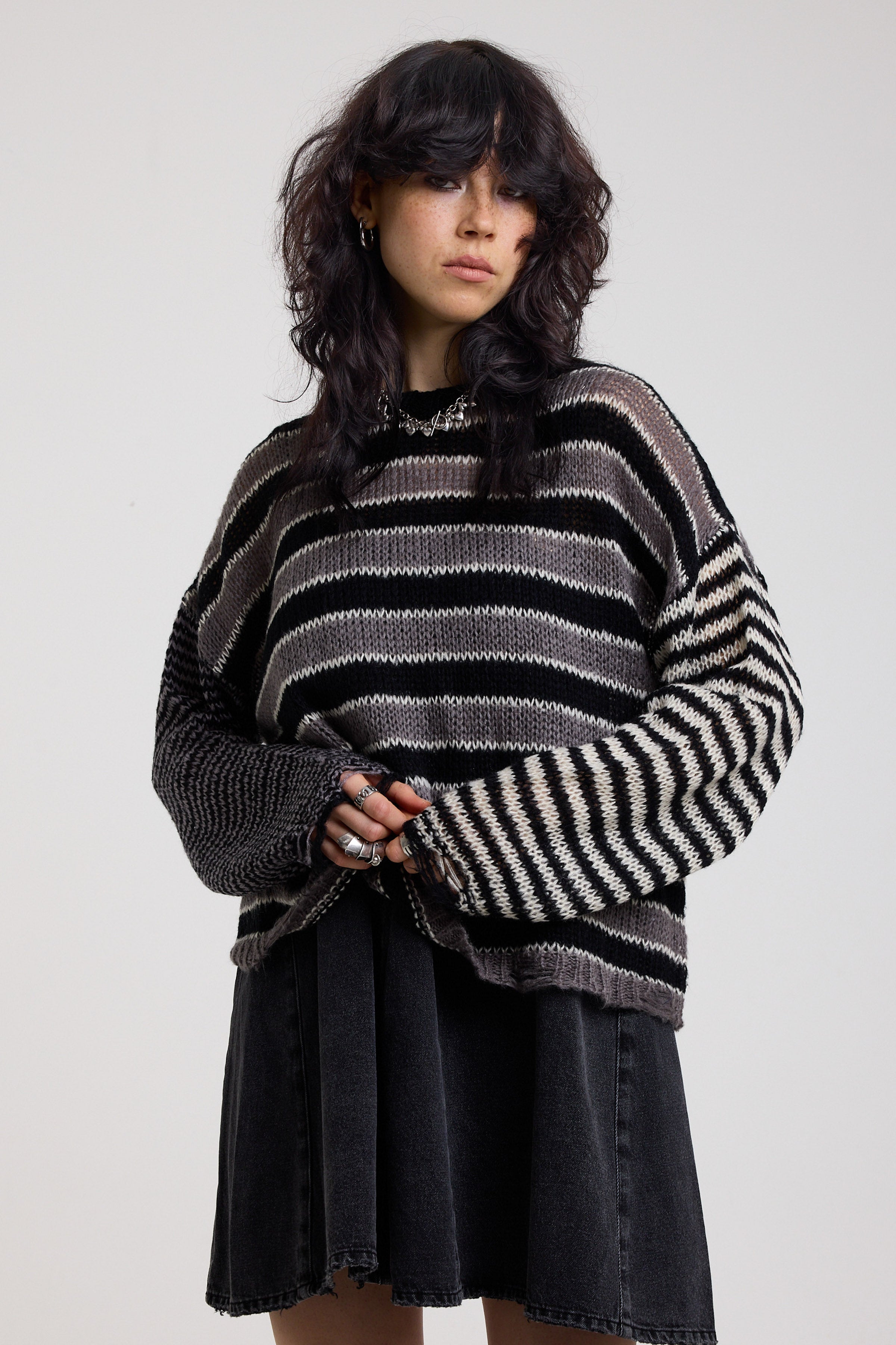 Black and white stripe oversized knit jumper with grunge distressed details, worn by model