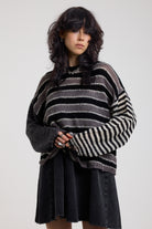 Black and white stripe oversized knit jumper with grunge distressed details, worn by model