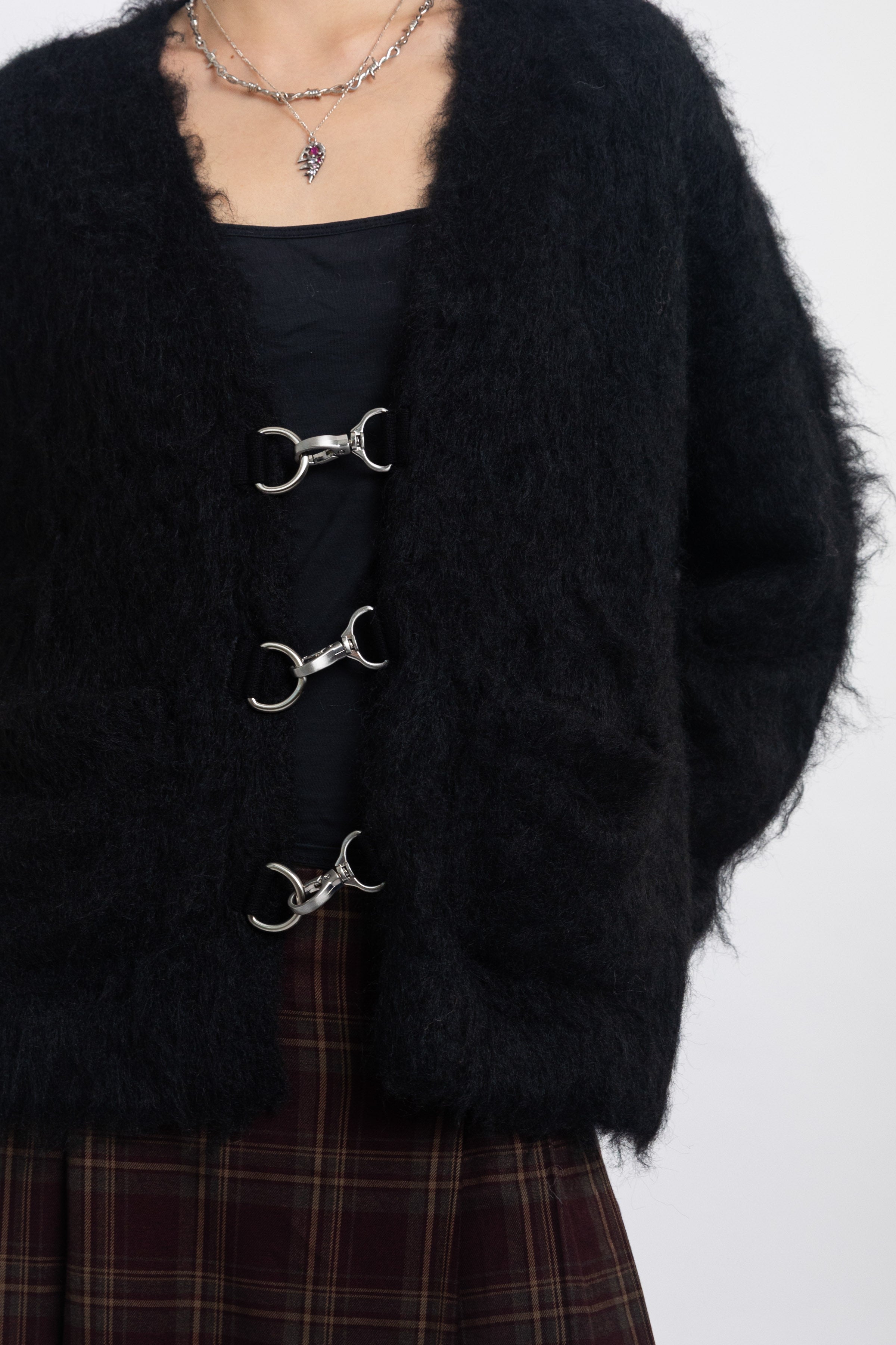 Black fluffy longline v-neck cardigan with oversized silver horsebit hardware clasps, worn by model