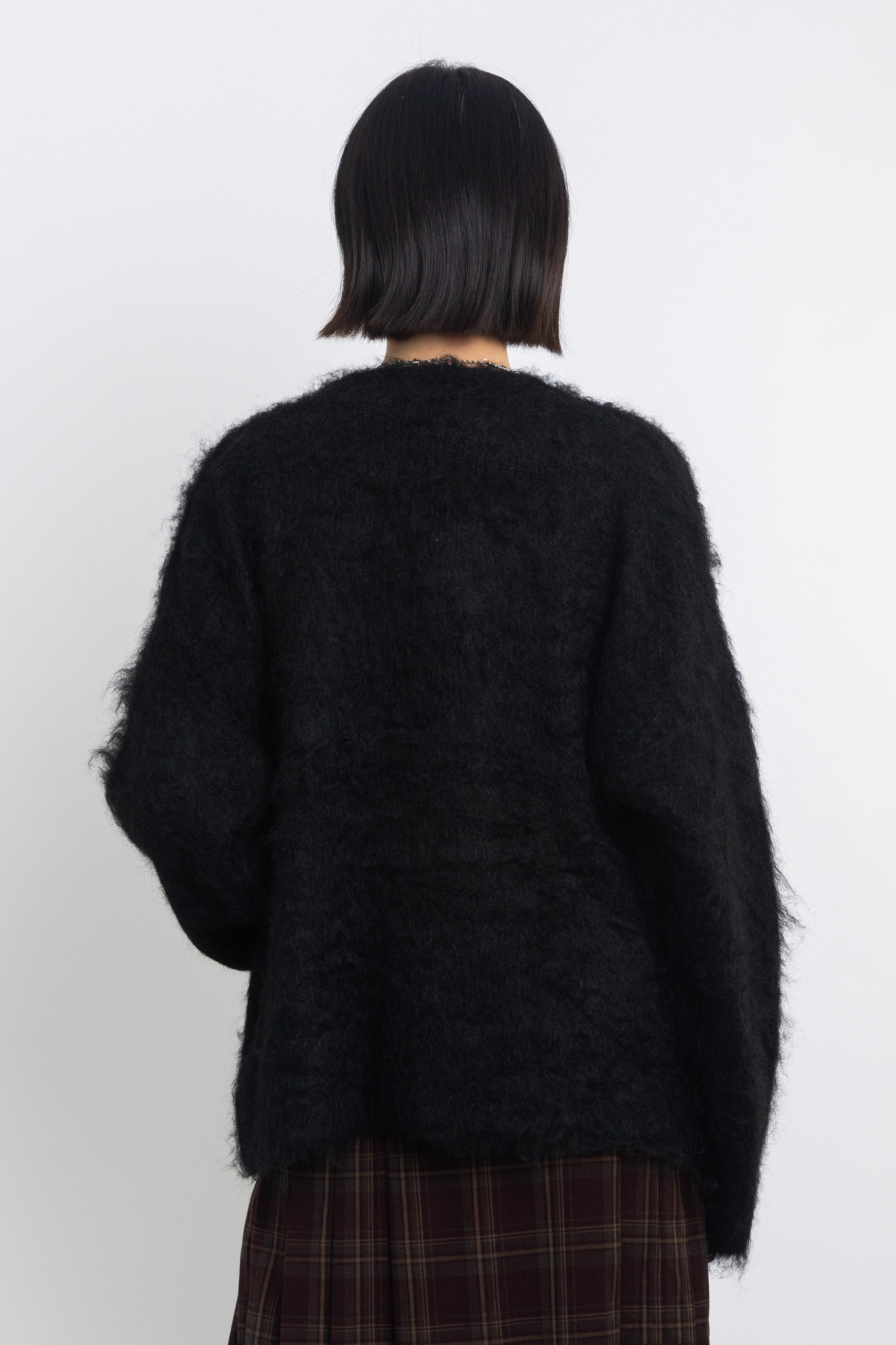 Black fluffy longline v-neck cardigan with oversized silver horsebit hardware clasps, worn by model