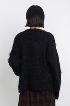 Black fluffy longline v-neck cardigan with oversized silver horsebit hardware clasps, worn by model