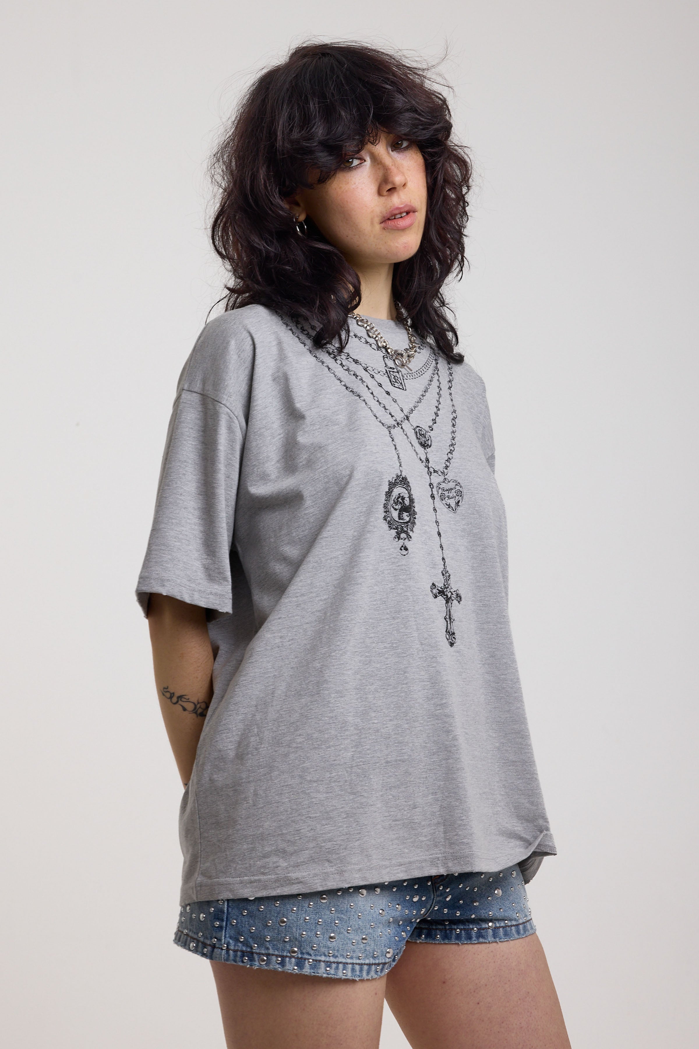 Grey marl oversized baby t-shirt with rosary pendants and cross necklace graphic, worn by a model