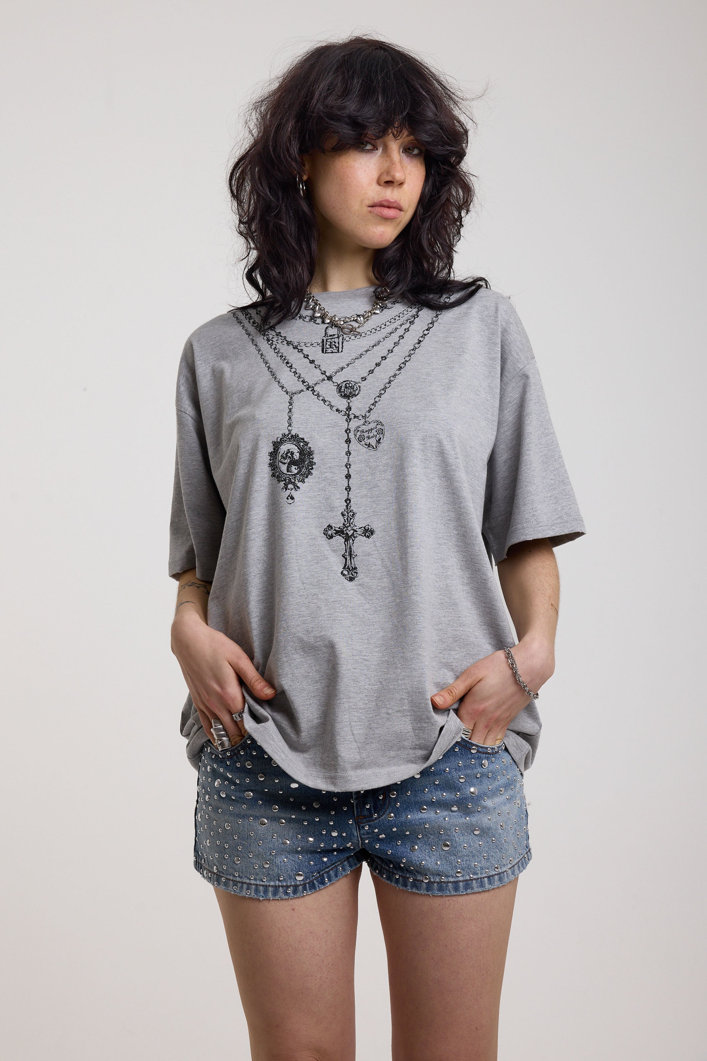 Grey marl oversized baby t-shirt with rosary pendants and cross necklace graphic, worn by a model