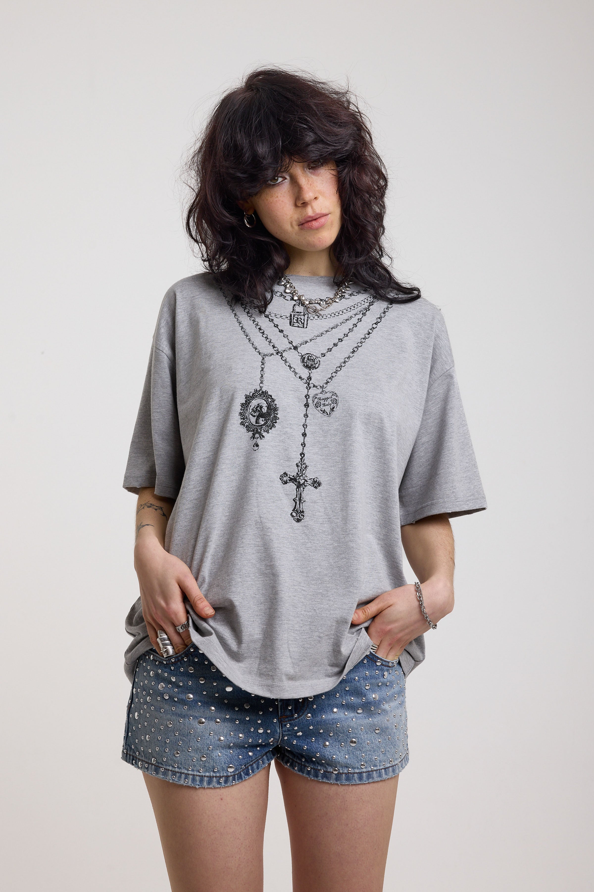Grey marl oversized baby t-shirt with rosary pendants and cross necklace graphic, worn by a model