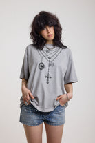 Grey marl oversized baby t-shirt with rosary pendants and cross necklace graphic, worn by a model