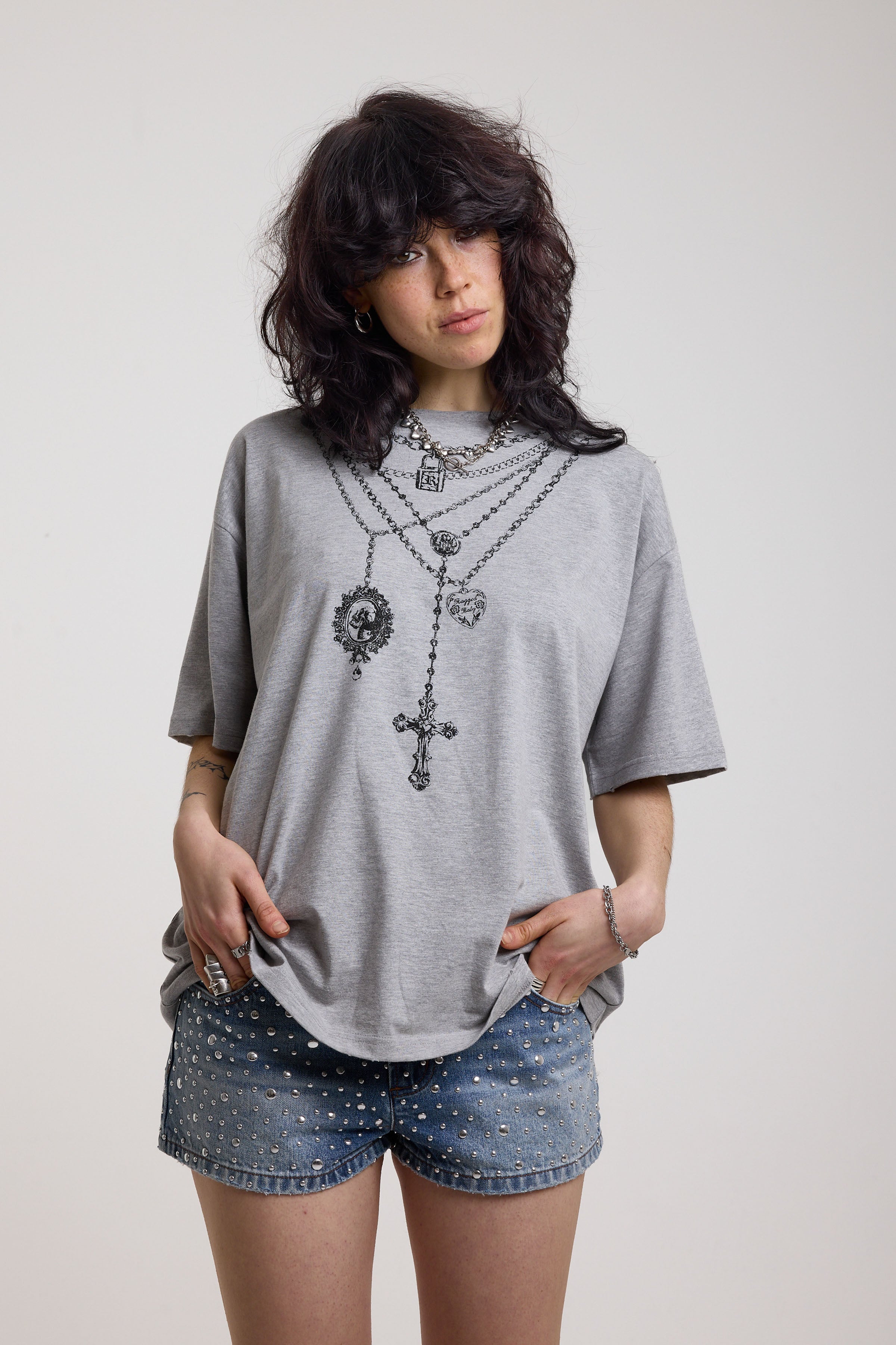 Grey marl oversized baby t-shirt with rosary pendants and cross necklace graphic, worn by a model