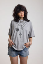 Grey marl oversized baby t-shirt with rosary pendants and cross necklace graphic, worn by a model