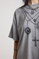Grey marl oversized baby t-shirt with rosary pendants and cross necklace graphic, worn by a model