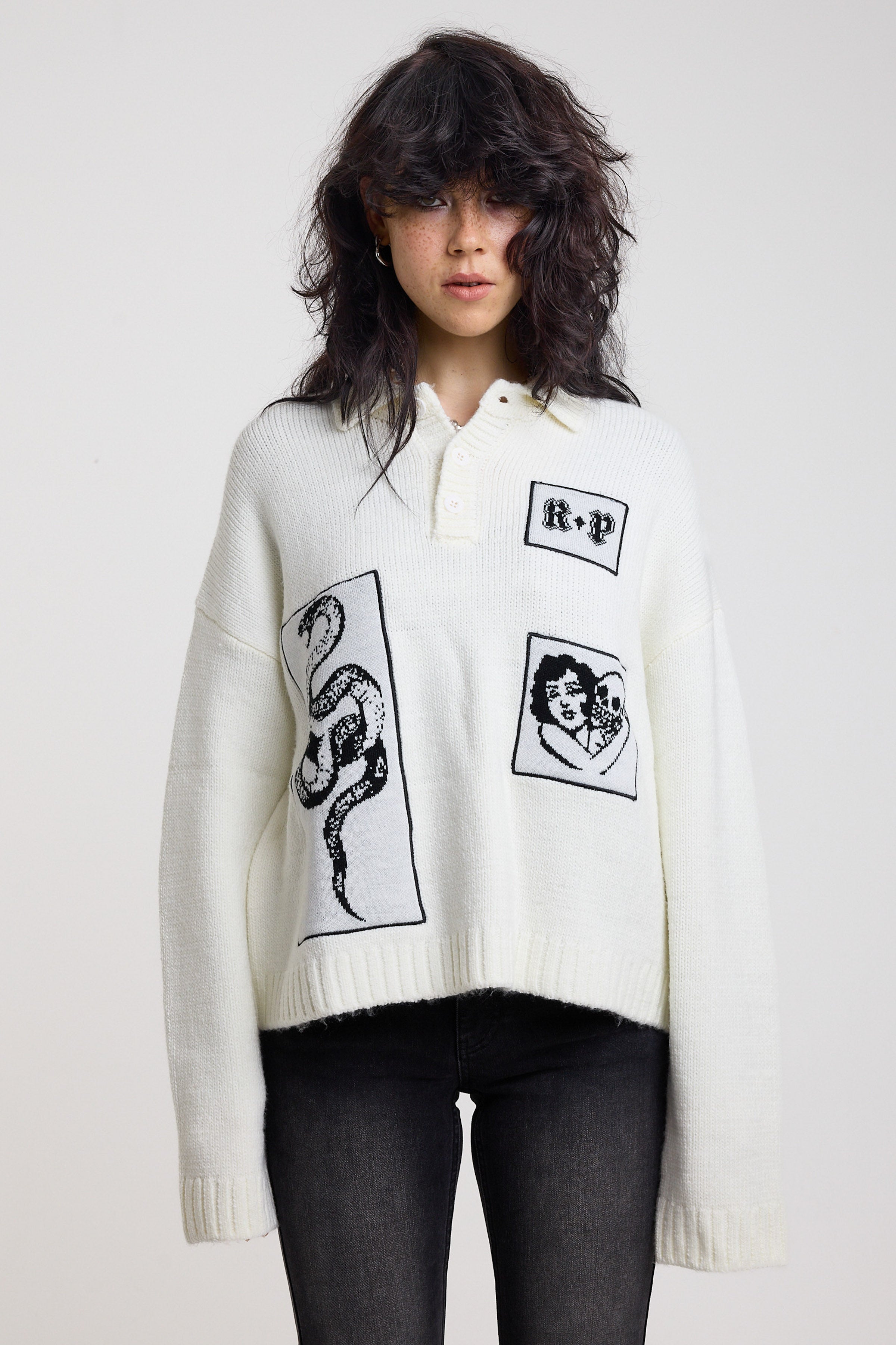 Cream oversized knit jumper with black graphic patch details and polo collar, worn by model