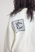 Close up of moon detail patch on cream oversized knit