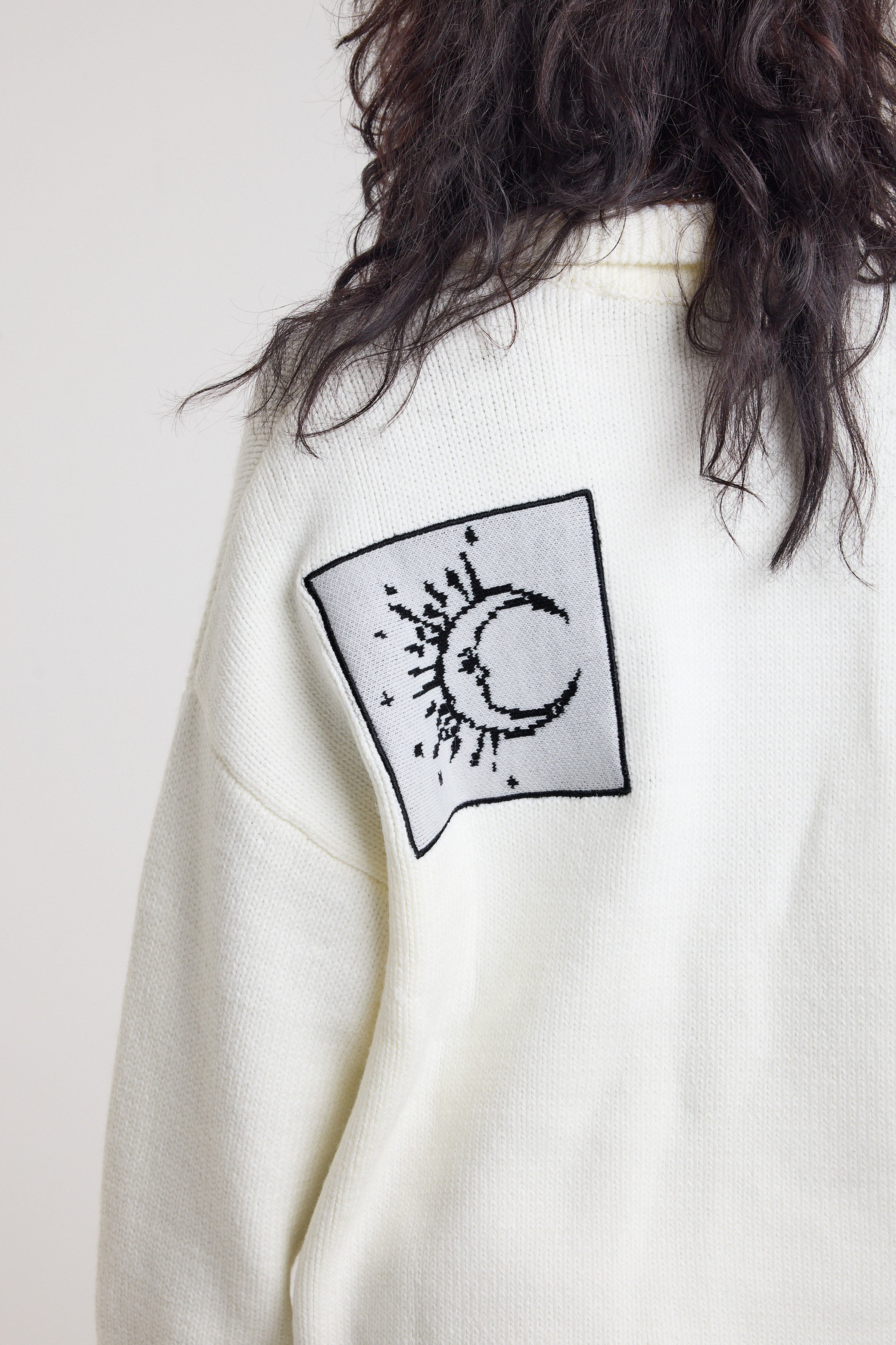 Close up of moon detail patch on cream oversized knit