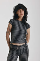 Grey and black stripe cap sleeve t-shirt with open back and eyelet buckle straps, worn by model