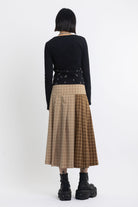 Spliced check pleated kilt midi skirt with silver clasp detail and thigh high split, worn by model