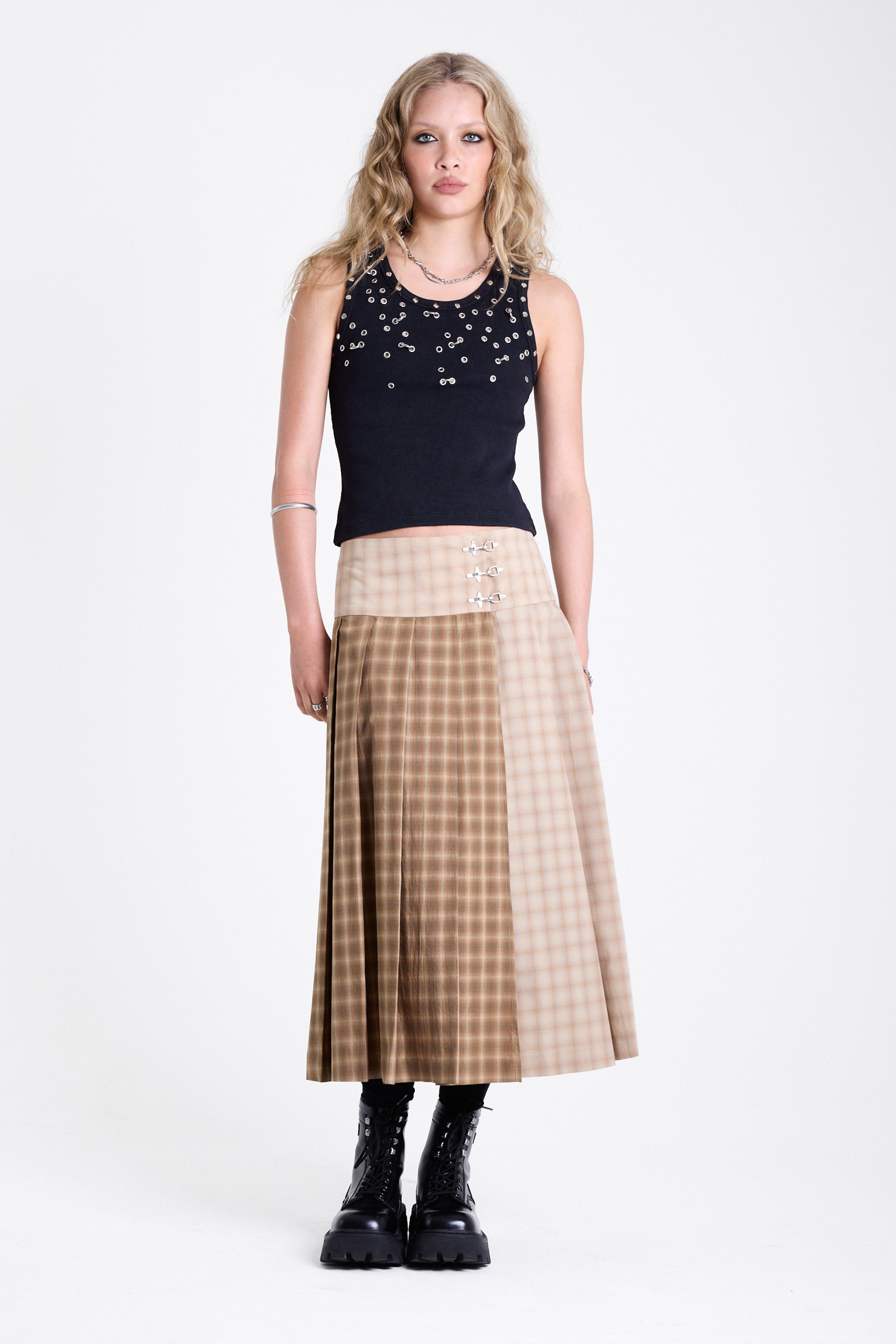 Beige and brown plaid pleated kilt maxi skirt with silver clasp detail and a wide waistband, worn by model