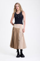 Beige and brown plaid pleated kilt maxi skirt with silver clasp detail and a wide waistband, worn by model