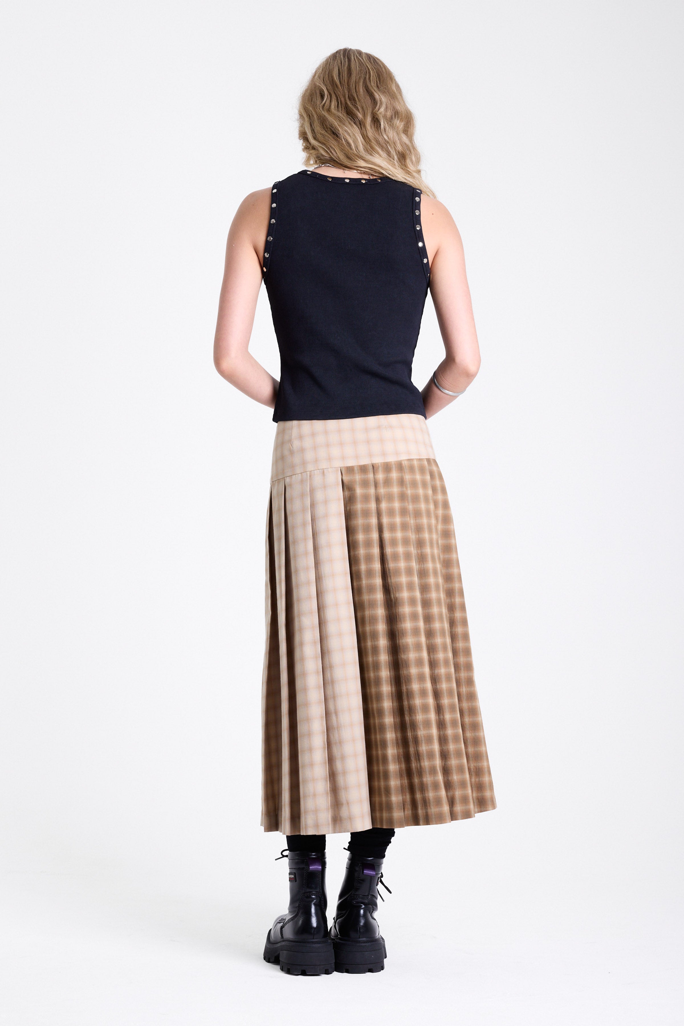 Beige and brown plaid pleated kilt maxi skirt with silver clasp detail and a wide waistband, worn by model