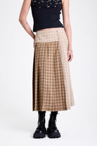 Beige and brown plaid pleated kilt maxi skirt with silver clasp detail and a wide waistband, worn by model