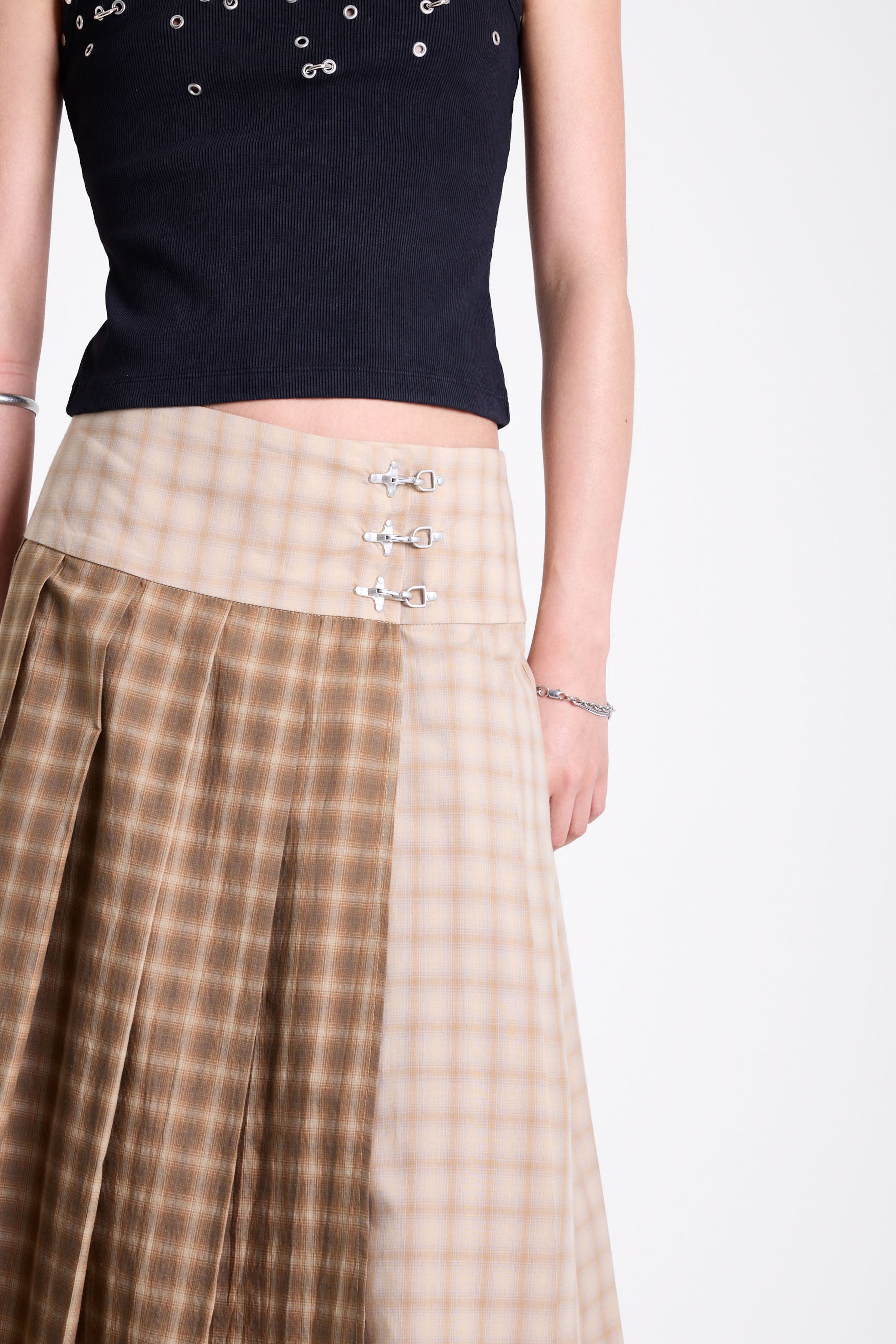 Beige and brown plaid pleated kilt maxi skirt with silver clasp detail and a wide waistband, worn by model