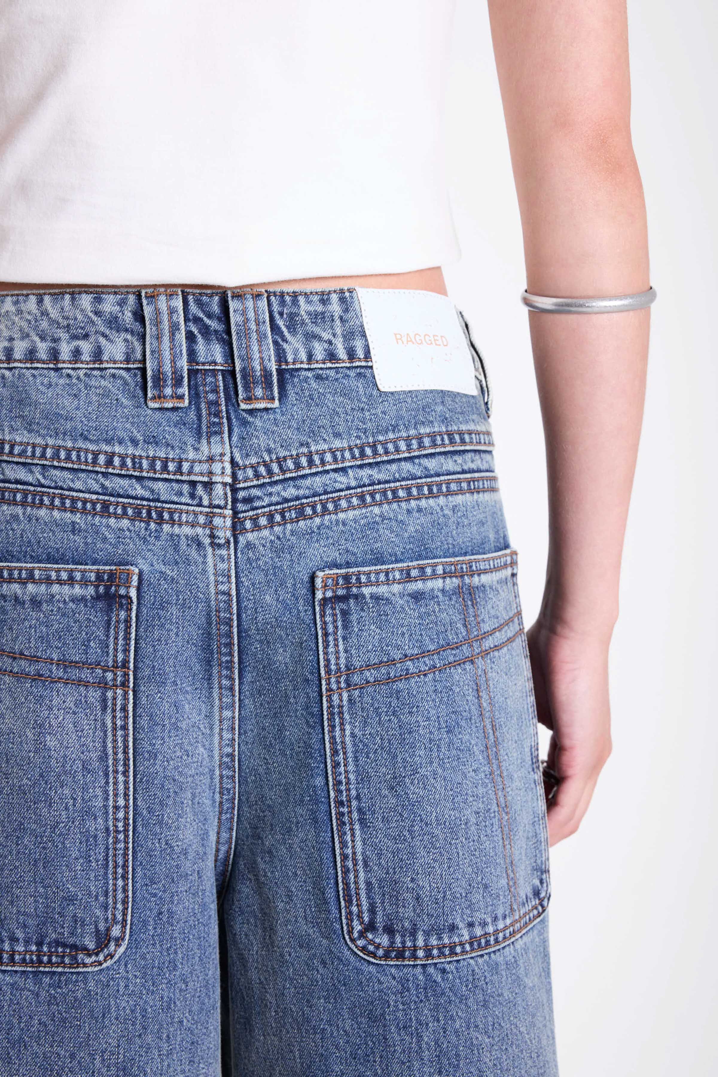 Vintage wash oversized baggy colossus jeans with silver eyelet and stud hardware detail, worn by model