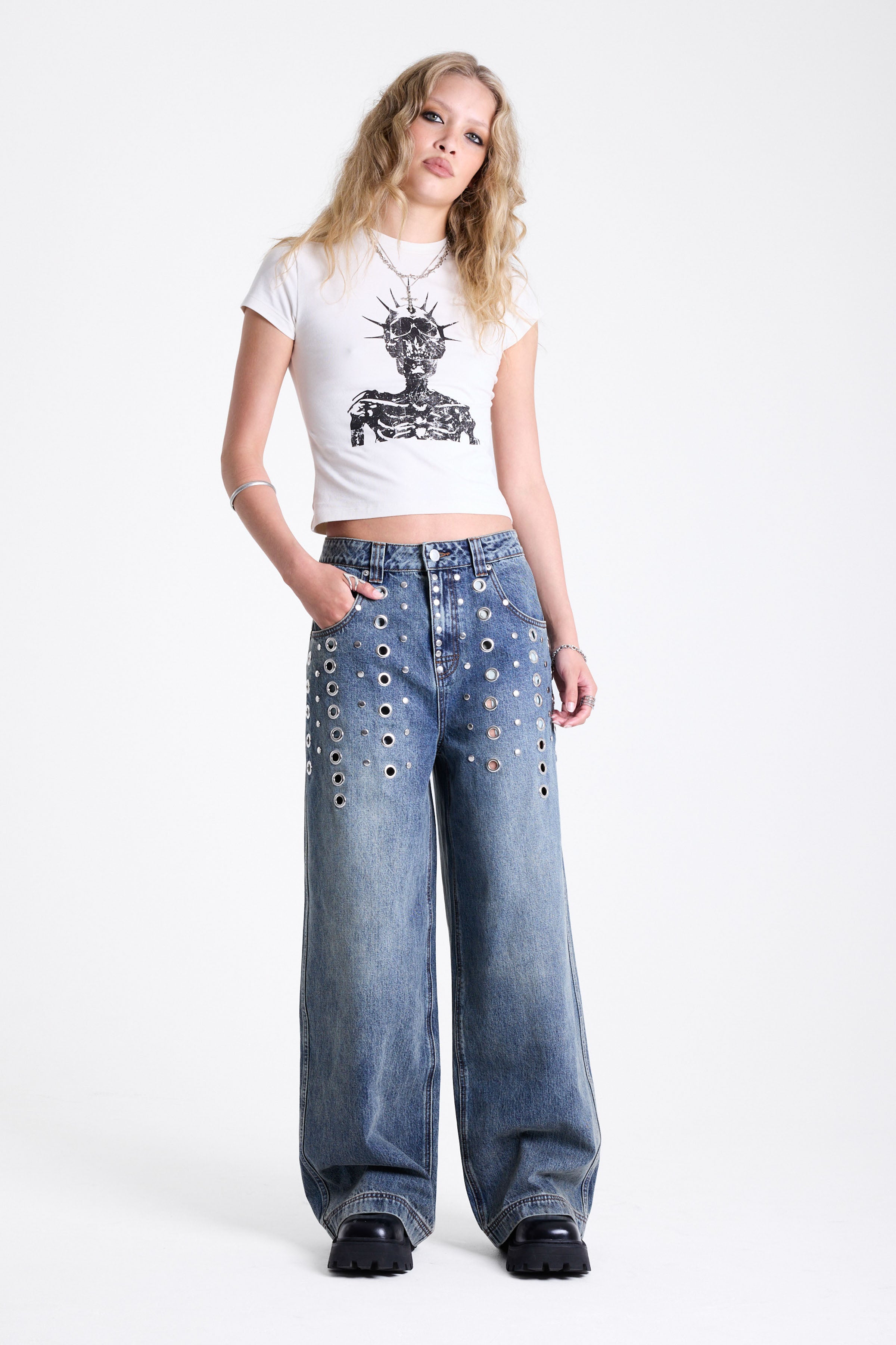 Vintage wash oversized baggy colossus jeans with silver eyelet and stud hardware detail, worn by model