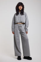 Grey wide leg trackpants with silver hardware clasp detail, worn by model