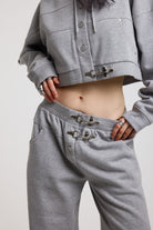 Close up of silver hardware clasps on grey wide leg trackpants, worn by model
