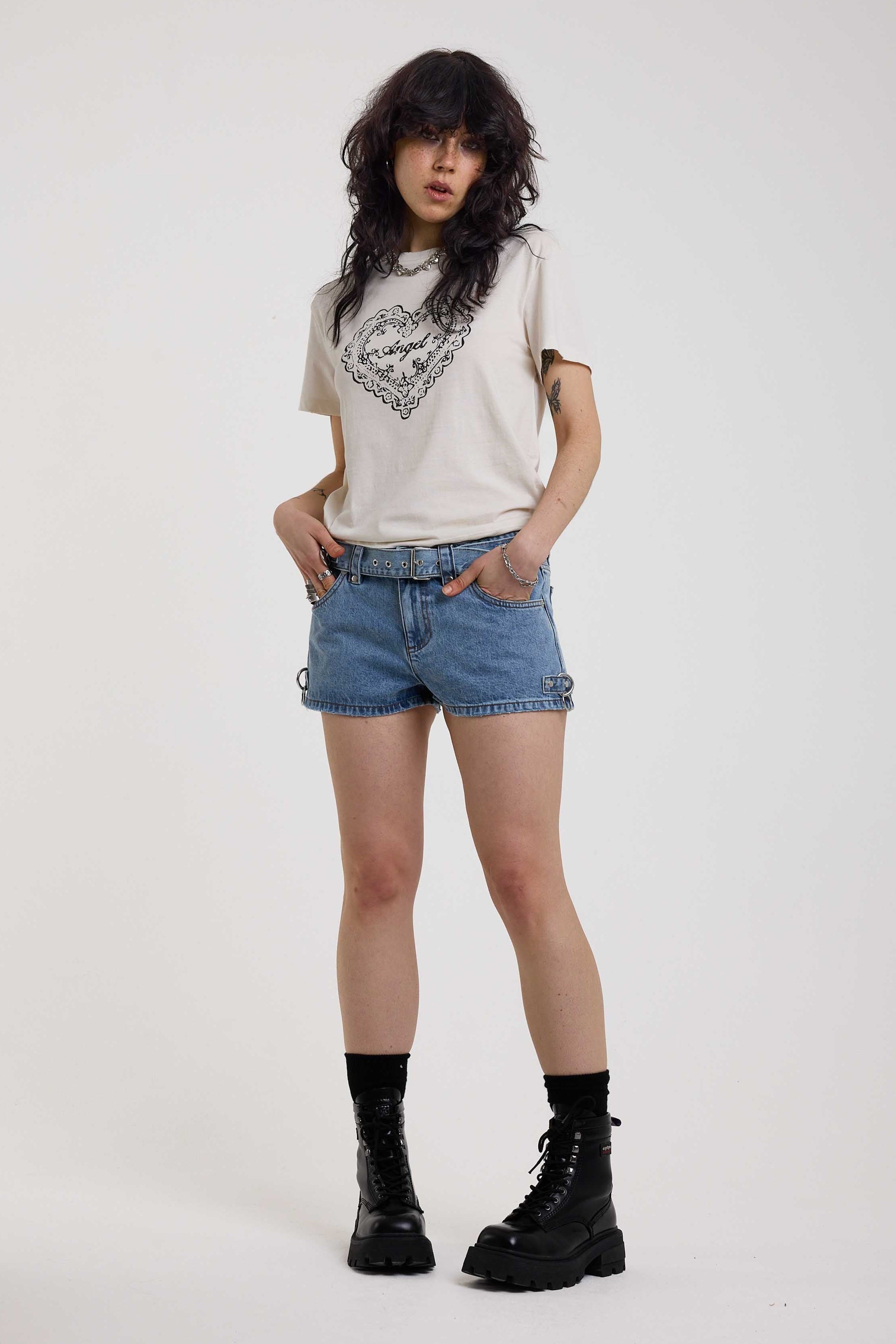 Light blue denim hotpants with silver D ring hardware and studded eyelet belt, worn by model