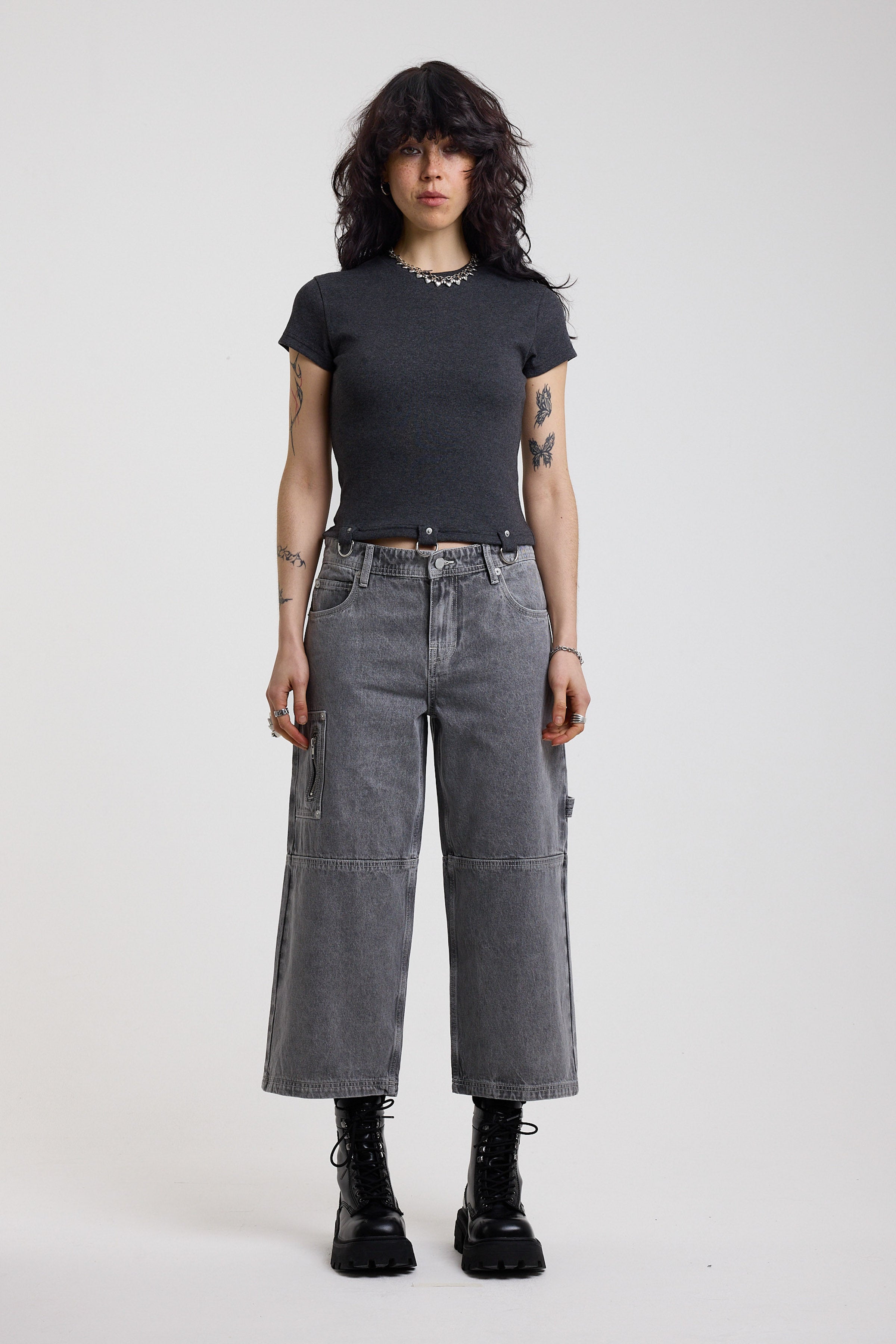 Washed grey baggy cropped carpenter jeans with hardware detail, worn by model