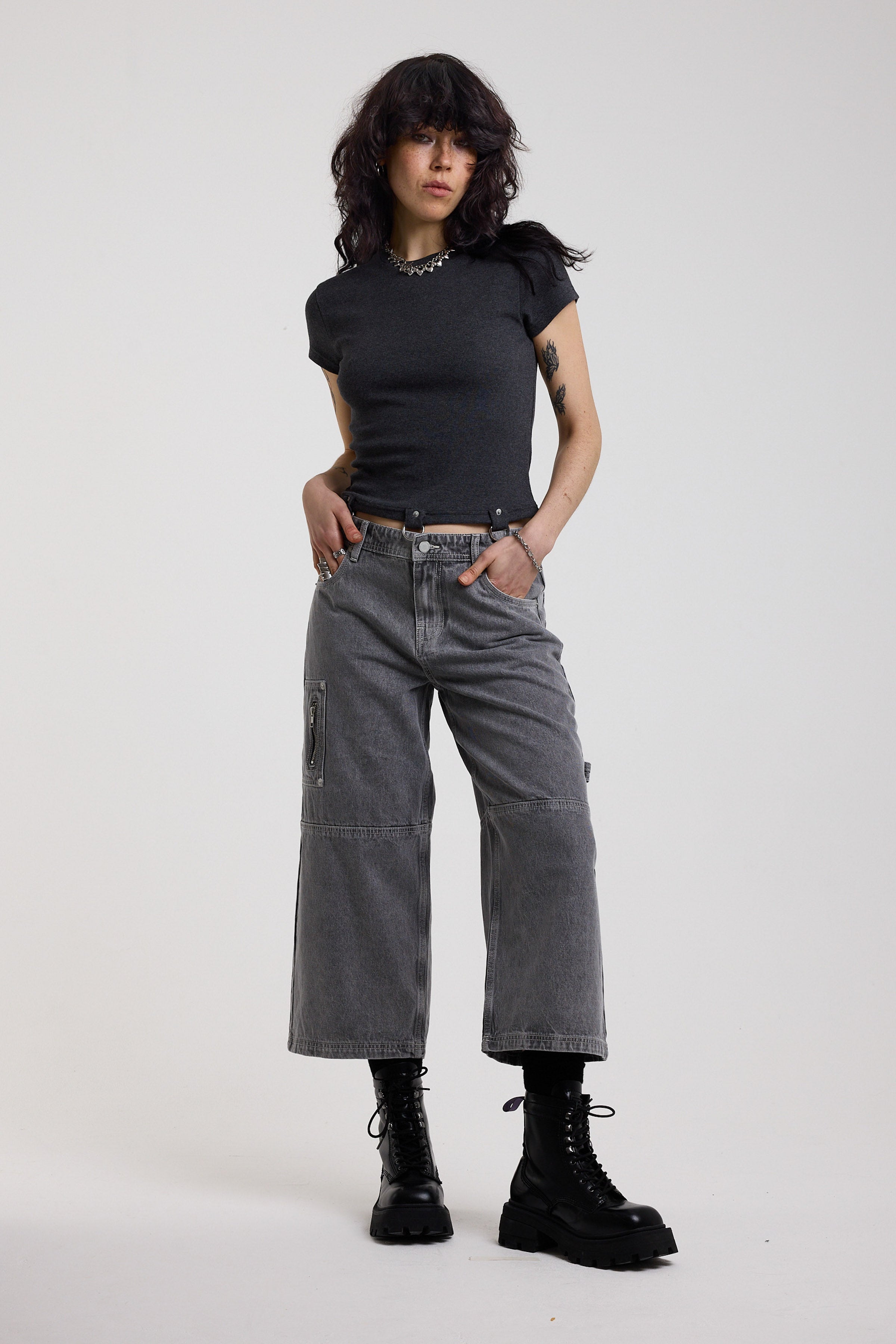 Washed grey baggy cropped carpenter jeans with hardware detail, worn by model