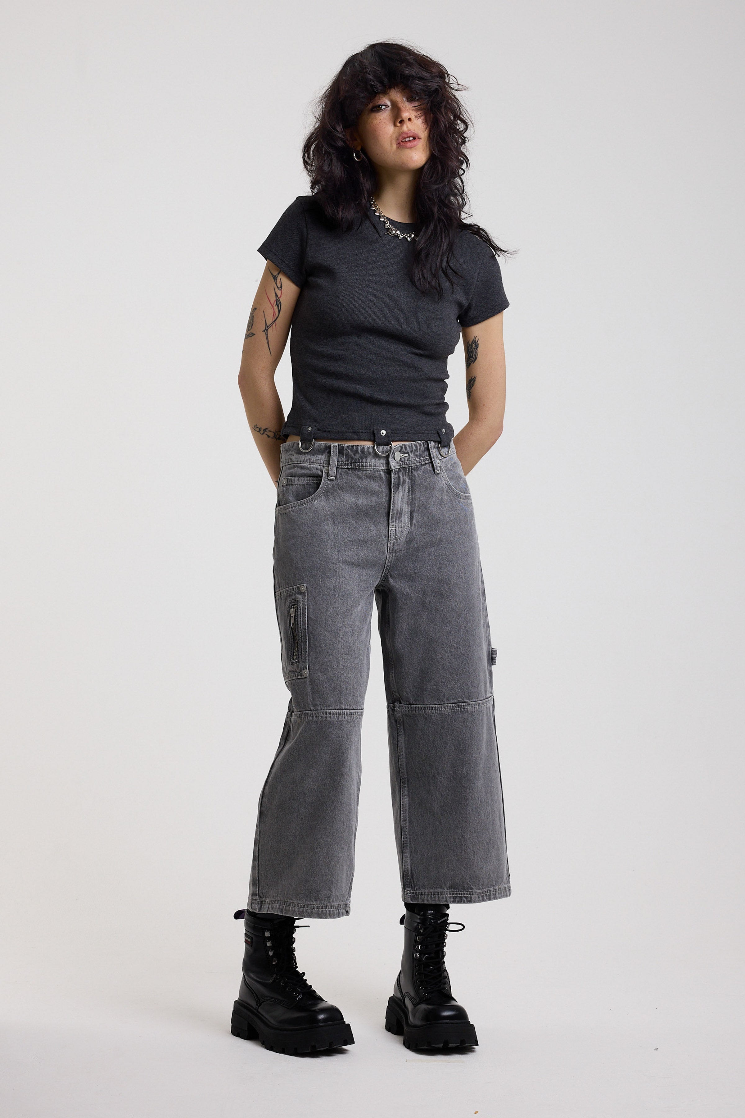 Washed grey baggy cropped carpenter jeans with hardware detail, worn by model