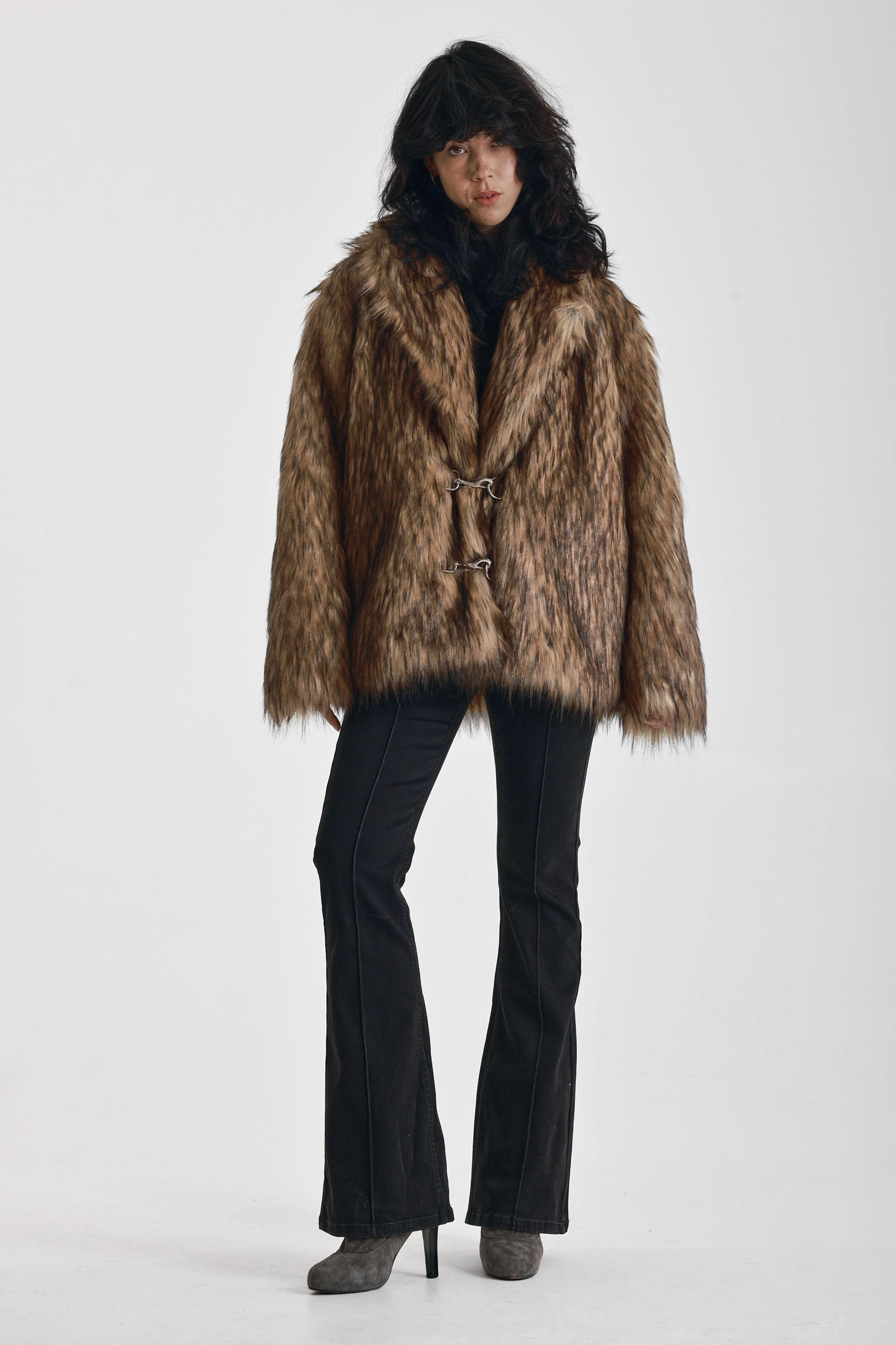 Oversized brown faux fur jacket with oversized collar and silver buckle clasps, worn by model