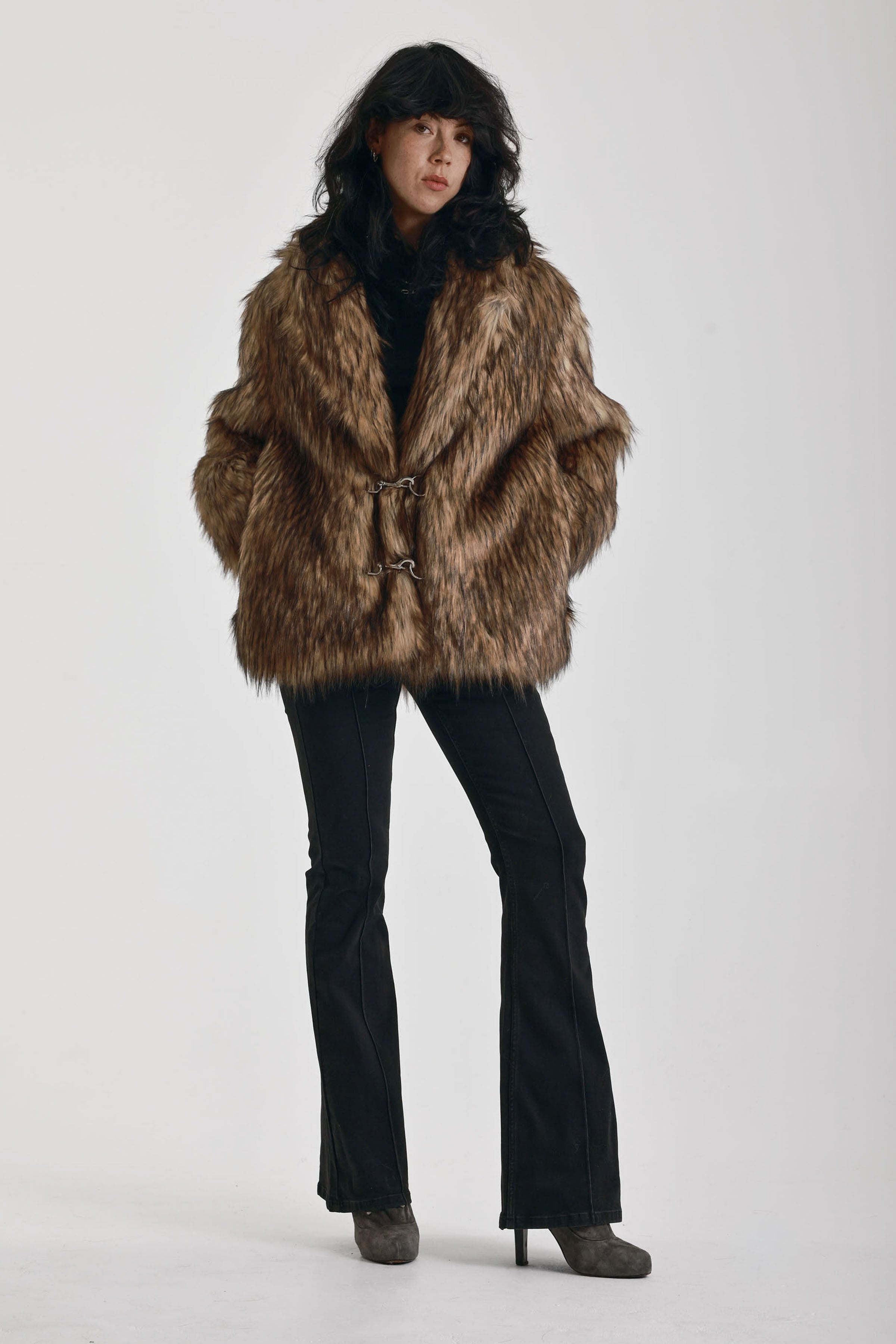 Oversized brown faux fur jacket with oversized collar and silver buckle clasps, worn by model