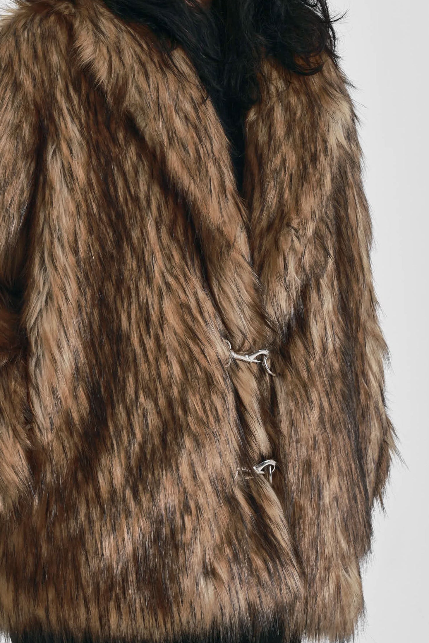 Oversized brown faux fur jacket with oversized collar and silver buckle clasps, worn by model
