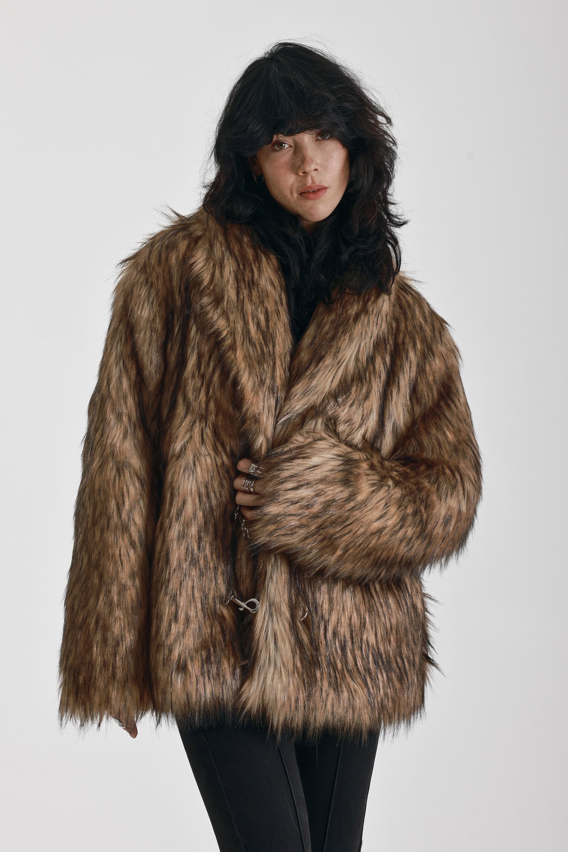 Oversized brown faux fur jacket with oversized collar and silver buckle clasps, worn by model